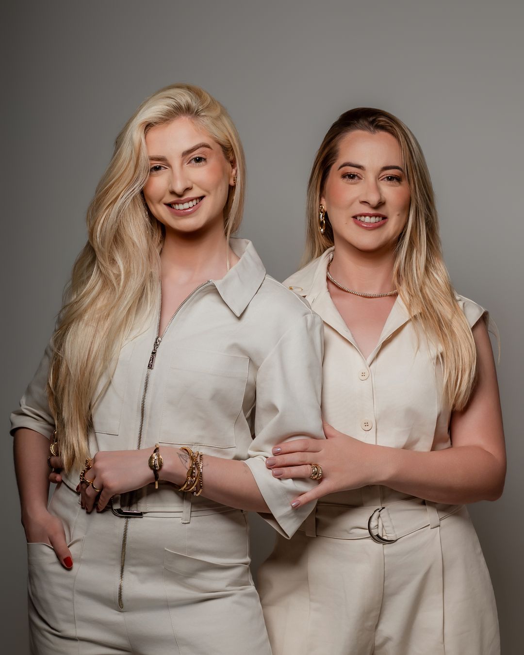 Ariane e Amanda, fundadoras da Voar ABA, sorrindo lado a lado, de braços dados.